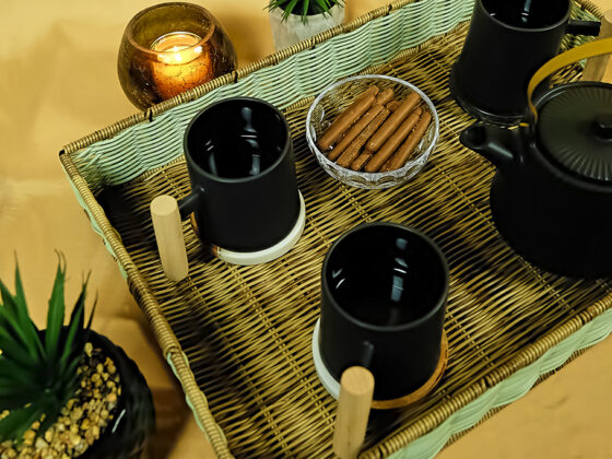 Plateau de thé en osier avec tasses et théière noires