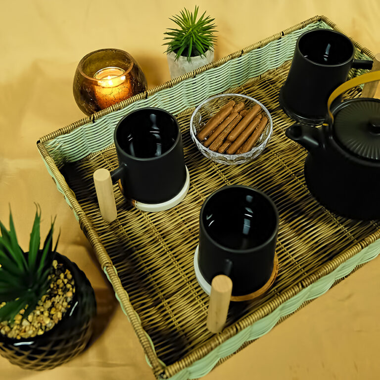 Plateau de thé en osier avec tasses et théière noires