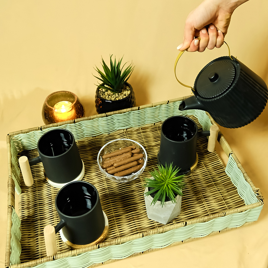 Plateau de thé en osier avec tasses et théière noires